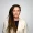 Jenni Monkiewicz The Portfolio Portrait of a woman with long dreadlocks in a cream blazer against a light gray background