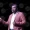 M Ananda Vardhan The Portfolio Male presenter in a pink blazer speaks on stage with a headset microphone holding a smartphone