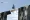 Revealing Structural Gaps in CSuite Succession Planning The Portfolio Businessman in a suit walks across an outstretched hand spanning a chasm briefcase in hand under a blue sky with The Portfolio Magazine logo in the corner