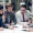 The Silent Power Play The Portfolio Four business professionals in suits sit around a table reviewing documents during a meeting The Portfolio Magazine logo appears in the top right corner