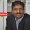 Rejin Surendran Appointed as CDO CIO at Britannia The Portfolio Portrait of a man in a dark suit and light blue shirt seated in front of bookshelves with a Britannia banner overlay indicating a feature for The Portfolio Magazine